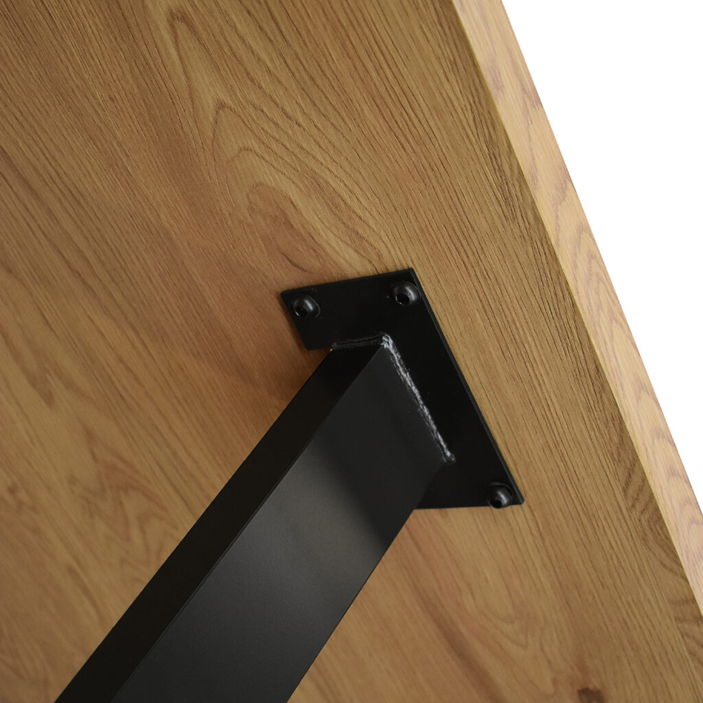 Angolo del piano rovere e gamba nera con inserto in legno del tavolo industrial
